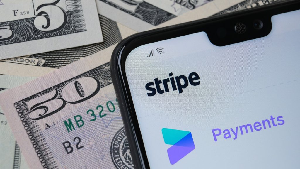 the stripe mobile app displays on a mobile phone, which sits on top of money