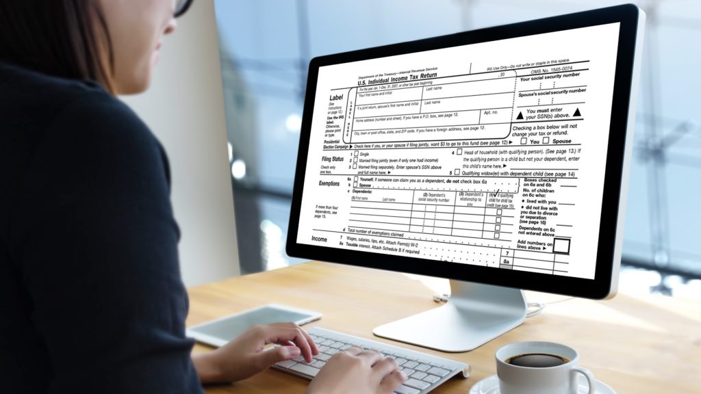 a tax preparer types on a computer
